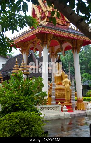 Statue di Buddha con offerte al Wat si Saket è un tempio buddista a Vientiane, la capitale e la più grande città del Laos. Foto Stock