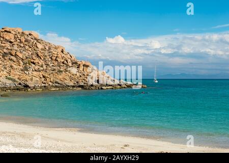 Persone snorkeling di una spiaggia a Isla ESpiritu Santo nella Bahia de la Paz, Mare di Cortez in Baja California, Messico con barca a vela nel backgrou Foto Stock