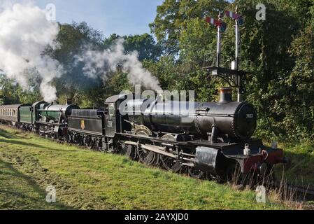 Un treno a doppia testata composto da 6960 Raveningham Hall e 7822 Foxcote Manor tirando una pioggia verso Minehead sulla West Somerset Railway. Foto Stock