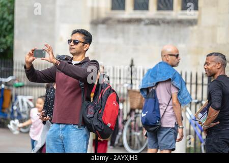 Cambridge, UK, 1 agosto 2019. Turisti in piedi verso il basso e di scattare foto a La strada di Cambridge per una intensa giornata di sole di fronte il Kings College Foto Stock