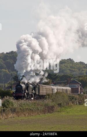 Un treno a doppia testata composto da 6960 Raveningham Hall e 7822 Foxcote Manor tirando una pioggia verso Minehead sulla West Somerset Railway. Foto Stock