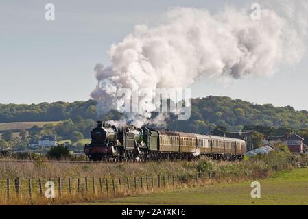 Un treno a doppia testata composto da 6960 Raveningham Hall e 7822 Foxcote Manor tirando una pioggia verso Minehead sulla West Somerset Railway. Foto Stock