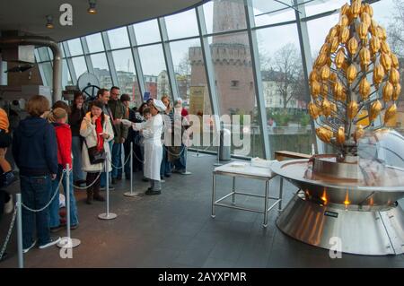 Donna che passa fuori campioni di cioccolato dalla fontana di cioccolato ai visitatori nel Imhoff-Schokoladenmuseum (museo del cioccolato Imhoff), situato nel Foto Stock