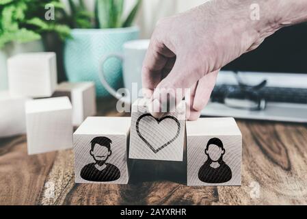 cadere in amore o concetto di relazione finale con icone avatar maschile e femminile e cuore su blocchi di legno Foto Stock