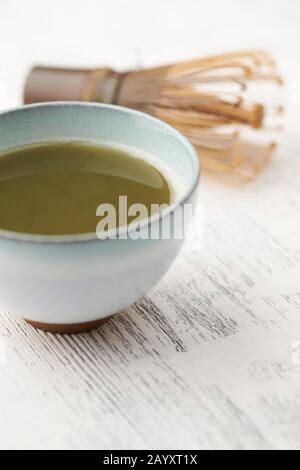 Tè Matcha verde e bambu' su sfondo di legno luminoso. Primo piano. Foto Stock