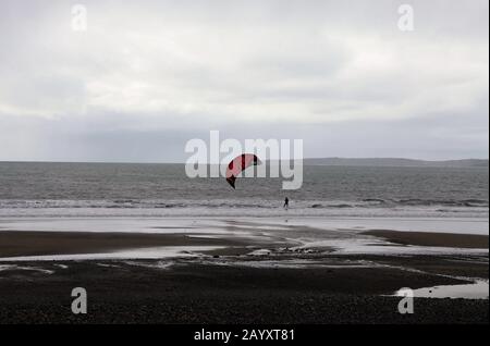 Kiteboarder in inverno a Garretstown Blue Flag Beach nella contea di Cork Foto Stock