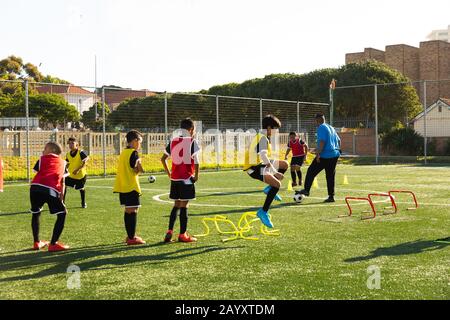 I bambini si allenano prima di giocare a calcio sul campo Foto Stock