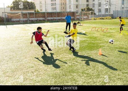 I bambini si allenano prima di giocare a calcio sul campo Foto Stock