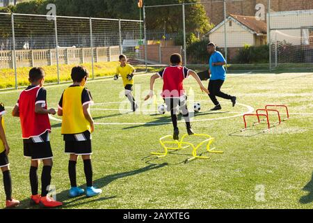 I bambini si allenano prima di giocare a calcio sul campo Foto Stock