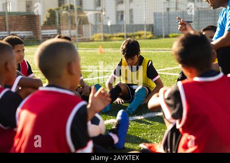 Giocatori di calcio che ascoltano il loro allenatore Foto Stock