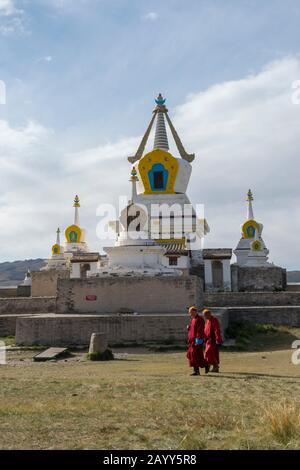 Monaci che camminano di fronte alla Stupa d'oro al monastero di Erdene Zuu a Kharakhorum (Karakorum), Mongolia. Foto Stock