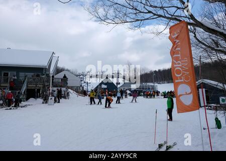 Bandiera arancione Camp Fortune e sciatori che si godono in Family Day, Chelsea, Quebec, Canada. Foto Stock
