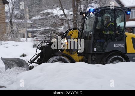 Spazzaneve che sgombrano il marciapiede in una fredda mattina invernale dopo una fresca nevicata, Ottawa, Ontario, Canada. Foto Stock