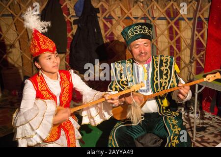 Padre e figlia suonano canzoni kazake tradizionali con dombras kazakh (strumento a corda) in un ger vicino alla città di Ulgii (Ölgii) nella Bayan-U. Foto Stock