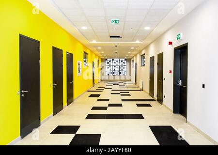 Corridoio della scuola con pareti gialle e bianche Foto Stock