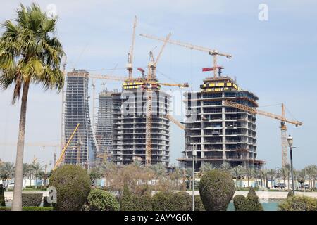 Doha / Qatar – 17 febbraio 2020: Lavori di costruzione in prossimità del lungomare della Marina nella zona di Lusail di Doha, tra cui le Torri Katara sullo sfondo Foto Stock