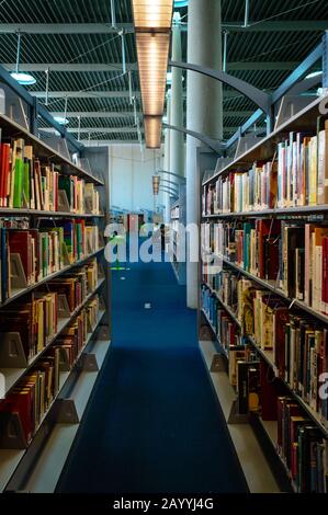 Corridoio di librerie impilate con libri alla Burton Barr Central Library nel centro di Phoenix, Arizona. Foto Stock
