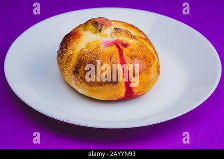 Bun con marmellata dolce rossa all'interno. Dolci da forno vicini Foto Stock