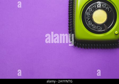 Telefono a rotazione vintage. Telefono classico verde con quadrante rotondo. Isolato su sfondo viola. Vecchia tecnologia di comunicazione. Spazio copia Foto Stock