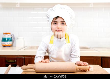 Faccia divertente dello chef del bambino. Chef bambino vestito cuoco  panettiere grembiule e cappello chef isolato su sfondo studio. Nutrizione  sana cibo per bambini Foto stock - Alamy