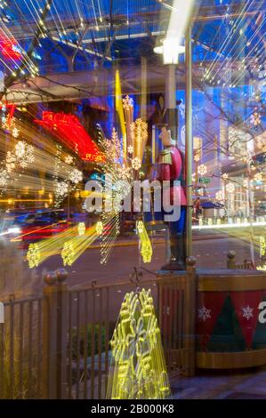 Una foto notturna (effetto zoom) delle decorazioni natalizie di Snowflake Lane con una statua batterista a Bellevue Square nel centro di Bellevue, Washington state, Foto Stock