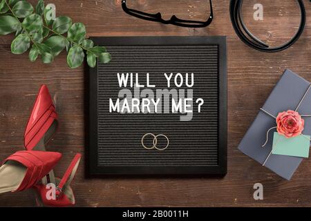 lettera bordo con testo di proposta 'mi sposerete?' su sfondo di legno Foto Stock