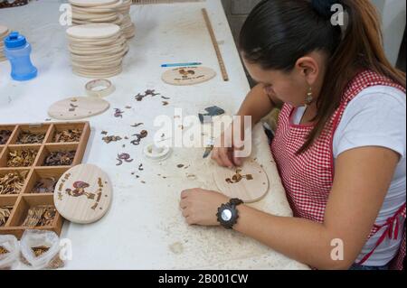 Un operaio produce souvenir in legno presso la fabbrica di souvenir in legno di Sr y Sra Ese a San Jose, la capitale della Costa Rica. Foto Stock