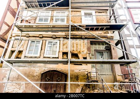 Impalcatura su una vecchia casa dilapidata a graticcio Foto Stock