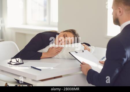 Il concetto di un cattivo avvocato notaio. Donna avvocato dormire su un cuscino in ufficio al tavolo Foto Stock