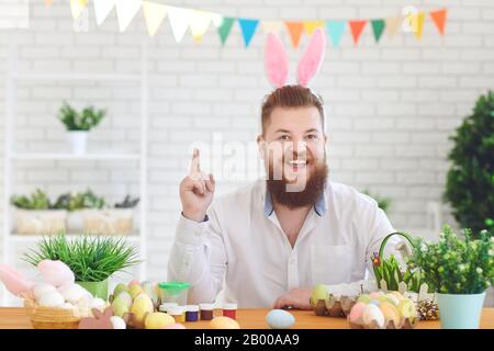 buona pasqua. Divertente uomo bearded uomo sorridente si fa notare indicando il dito sullo sfondo di Pasqua Foto Stock