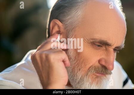 Primo piano immagine di un uomo che collega auricolari wireless Foto Stock