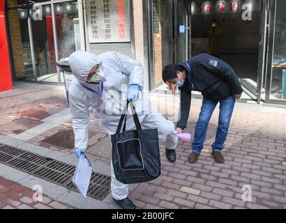 (200218) -- WUHAN, 18 febbraio 2020 (Xinhua) -- un membro del personale viene disinfettato prima di partecipare a una campagna di screening sanitario presso la Comunità di Qinghuju nel distretto di Qingshan, Wuhan, capitale della provincia dell'Hubei nella Cina centrale, 18 febbraio 2020. Wuhan lancia una serie di misure di ampia portata e più rigorose dal 17to 19 febbraio per controllare l'epidemia. (Xinhua/Cheng Min) Foto Stock