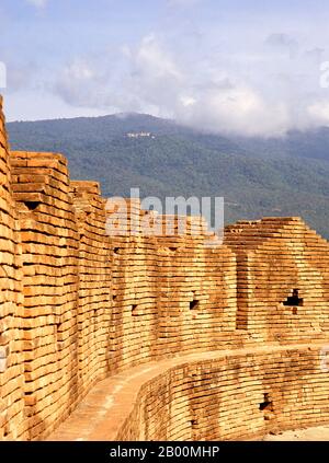 Thailandia: Doi Suthep visto da Jaeng Ku Ruang (Bastione Ku Ruang), Chiang mai. Chiang mai, talvolta scritto come 'Chiengmai' o 'Chiangmai', è la città più grande e culturalmente significativa del nord della Thailandia, ed è la capitale della provincia di Chiang mai. Si trova a 700 km (435 mi) a nord di Bangkok, tra le montagne più alte del paese. La città si trova sul fiume Ping, un importante affluente del fiume Chao Phraya. Re Mengrai fondò la città di Chiang mai (che significa "nuova città") nel 1296, e succedette a Chiang Rai come capitale del regno Lanna. La città era circondata da un fossato. Foto Stock