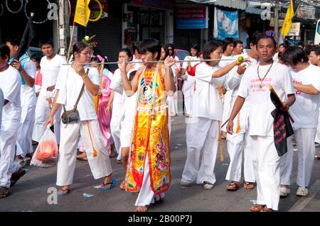 Thailandia: Il devoto o 'ma Song' partecipa a una processione attraverso la città di Phuket, Phuket Vegetarian Festival. Il Festival vegetariano è un festival religioso che si tiene ogni anno sull'isola di Phuket, nel sud della Thailandia. Attrae folle di spettatori a causa di molti degli insoliti rituali religiosi che vengono eseguiti. Molti devoti religiosi si schianteranno di spade, perforeranno le loro guance con oggetti taglienti e commetteranno altri atti dolorosi. Foto Stock