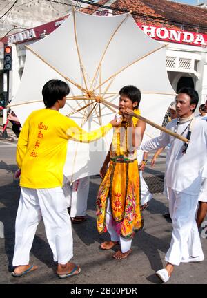 Thailandia: Il devoto o 'ma Song' partecipa a una processione attraverso la città di Phuket, Phuket Vegetarian Festival. Il Festival vegetariano è un festival religioso che si tiene ogni anno sull'isola di Phuket, nel sud della Thailandia. Attrae folle di spettatori a causa di molti degli insoliti rituali religiosi che vengono eseguiti. Molti devoti religiosi si schianteranno di spade, perforeranno le loro guance con oggetti taglienti e commetteranno altri atti dolorosi. Foto Stock