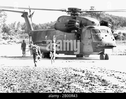 Cambogia: L'incidente di Mayaguez, 12-15 maggio 1975. Un soldato USAF del 40° Squadrone di soccorso e recupero aerospaziale guida Marines a un elicottero HH-53. Il 12 maggio 1975, i Khmer Rossi sequestrarono la USS Mayaguez e il suo equipaggio nelle acque territoriali cambogiane mentre erano in rotta per la Thailandia. Gli Stati Uniti hanno lanciato per la prima volta una missione di salvataggio che si è conclusa in un disastro dopo che un elicottero si è schiantato. Un massiccio assalto è stato lanciato il 14-15 maggio e la maggior parte dell'equipaggio è stato salvato dall'isola di Koh Tang, ma non prima che entrambe le parti avevano perso oltre una dozzina di vittime. Foto Stock