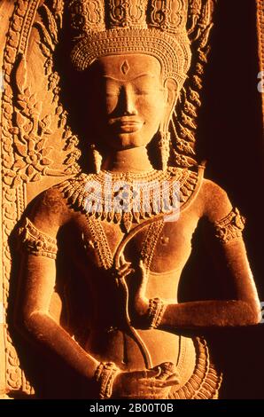 Cambogia: Il sole del tardo pomeriggio illumina un apsara (Ninfa Celestiale) al livello superiore del santuario centrale, Angkor Wat. Angkor Wat fu costruito per il re Suryavarman II (governato dal 1113 al 50) all'inizio del XII secolo come tempio di stato e capitale. Come il tempio meglio conservato del sito di Angkor, è l'unico ad essere rimasto un centro religioso significativo sin dalla sua fondazione - prima indù, dedicato al dio Vishnu, poi buddista. E' il più grande edificio religioso del mondo. Il tempio è in cima allo stile classico dell'architettura Khmer. Foto Stock