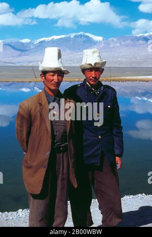 Cina: Uomini Kirghiz vicino al lago Karakul sulla Karakoram Highway, Xinjiang. Due piccoli insediamenti di nomadi Kirghiz (Kirghizistan o Kirgiz) si trovano sul lato del lago Karakul in alto sulle montagne del Pamir. I visitatori possono pernottare in una delle loro case mobili o yurts - gli uomini di Kirghiz si avvicinano ai viaggiatori quando arrivano al lago e si offrono di organizzare questo alloggio. Il Kirghizistan è uno dei 56 gruppi etnici ufficialmente riconosciuti dalla Repubblica popolare cinese. Ci sono più di 145,000 Kirghizistan in Cina. Foto Stock