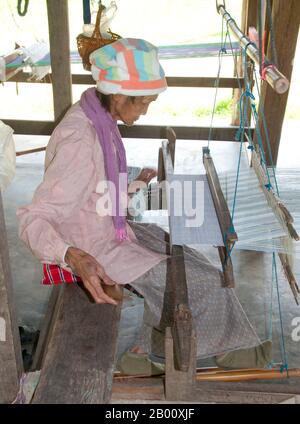 Thailandia: Un tessitore si trova sotto una tradizionale casa di Tai Dam, Ban Na Pa Nat Tai Dam Villaggio Culturale, Provincia di Loei. La Diga di Tai o Tai Nero sono un gruppo etnico che si trova in alcune parti del Laos, Vietnam, Cina e Thailandia. I parlanti di Tai Dam in Cina sono classificati come parte della nazionalità dai insieme a quasi tutti gli altri popoli Tai. Ma in Vietnam loro viene data la propria nazionalità (con il Tai Bianco), dove sono classificati come la nazionalità Thái (che significa popolo Tai). La diga di Tai ha origine dalle vicinanze di Dien Bien Phu in Vietnam. Foto Stock