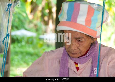 Thailandia: Un tessitore si trova sotto una tradizionale casa di Tai Dam, Ban Na Pa Nat Tai Dam Villaggio Culturale, Provincia di Loei. La Diga di Tai o Tai Nero sono un gruppo etnico che si trova in alcune parti del Laos, Vietnam, Cina e Thailandia. I parlanti di Tai Dam in Cina sono classificati come parte della nazionalità dai insieme a quasi tutti gli altri popoli Tai. Ma in Vietnam loro viene data la propria nazionalità (con il Tai Bianco), dove sono classificati come la nazionalità Thái (che significa popolo Tai). La diga di Tai ha origine dalle vicinanze di Dien Bien Phu in Vietnam. Foto Stock