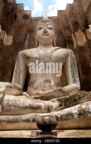 Thailandia: 15 metri di altezza Buddha seduto, Wat si Chum, Sukhothai storico Parco. Il Buddha di Phra Atchana a Wat si Chum è nella postura di 'Subduing Maraa' o 'chiamare la Terra a testimoniare'. Sukhothai, che letteralmente significa "Alba della felicità", fu la capitale del regno di Sukhothai e fu fondata nel 1238. Fu la capitale dell'Impero Tailandese per circa 140 anni. Foto Stock