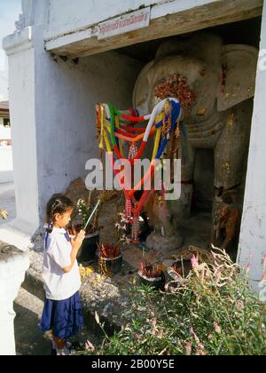 Thailandia: Giovane ragazza che paga i rispetti al santuario bianco dell'elefante vicino alla porta di Chang Phuak, Chiang mai, Thailandia del Nord. Il "Monumento dell'Elefante Albino" di Chiang mai, più comunemente reso in inglese come "Monumento dell'Elefante Bianco", è anche noto come Khuang Chang Phuak o "Terrazza dell'Elefante Bianco". Khuang Chang Puak risale al tempo del re Saen Muang ma, il decimo sovrano della dinastia Mangrai (1385-1401). Re Mengrai fondò la città di Chiang mai (che significa "nuova città") nel 1296, e succedette a Chiang Rai come capitale del regno Lanna. A volte è scritto come 'Chiengmai' o 'Chiangmai'. Foto Stock