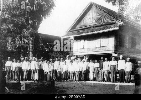 Cambogia: Studenti musulmani e insegnanti posa per una fotografia nel 1918 fuori della loro madrassa a Phnom Penh. In Cambogia, l'Islam è la religione della maggior parte del popolo Cham e di alcune minoranze malesi. Nel 1975, secondo quanto riferito, ci sono stati da 150,000 a 200,000 musulmani a livello nazionale. Tuttavia, la persecuzione sotto i Khmer rossi ha gravemente eroso il loro numero. Nel 2009, il Centro di ricerca Pew ha stimato la popolazione musulmana della Cambogia a 236,000. Tutti i musulmani di Cham sono sunniti della scuola di Shfi'i. C'è anche una crescente comunità musulmana di Ahmadiyya nel paese. Foto Stock