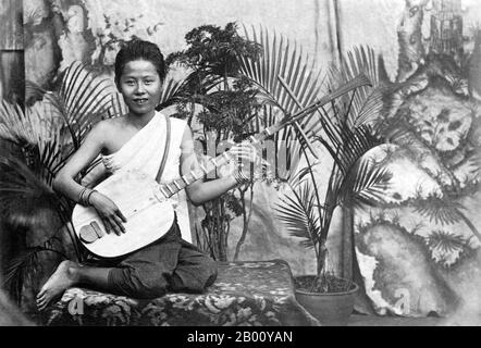 Cambogia: Una fotografia del 1928 di un giovane musicista che suona un 'chapei' nel Palazzo reale di Phnom Penh. Un 'chapei dong veng' è una chitarra tradizionale Khmer a due corde e a collo lungo. La ragazza nella foto molto probabilmente avrebbe giocato alla corte del re Sisowath Monivong che era il re della Cambogia dal 1927 fino al 1941. Foto Stock