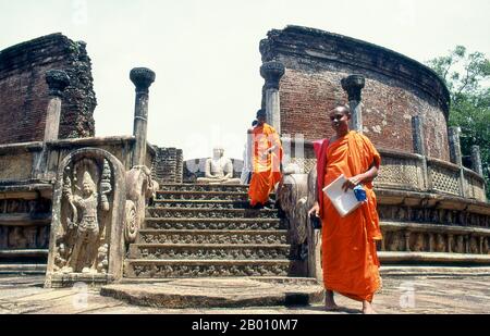 Sri Lanka: Monaci di fronte al Vatadage (casa reliquia circolare), Polonnaruwa. Vatadage è un tipo di struttura buddista che si trova nello Sri Lanka. È anche conosciuto come un dage, thupagara e cetiyagara. I Vatadages sono stati costruiti intorno ai piccoli stupa per la loro protezione, che spesso hanno consacrato una reliquia o sono stati costruiti su terreno hallowed. Polonnaruwa, il secondo più antico dei regni dello Sri Lanka, fu dichiarato per la prima volta capitale dal re Vijayabahu i, che sconfisse gli invasori Chola nel 1070 d.C. per riunire il paese sotto un leader nazionale. Foto Stock