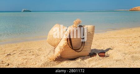 Borsa e hat sulla spiaggia vicino al mare. Messa a fuoco selettiva. la natura. Foto Stock