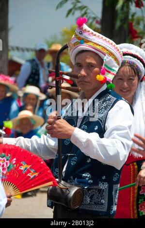 Cina: Un uomo Bai porta un erhu (violino cinese), musica Bai e festival di danza a Santa si (tre Pagodas), Dali, Yunnan. I Bai o Baip sono uno dei 56 gruppi etnici ufficialmente riconosciuti dalla Repubblica popolare Cinese. I Bai vivono soprattutto nelle province di Yunnan (zona di Dali), e nelle vicine province di Guizhou (zona di Bijie) e Hunan (zona di Sangzhi). Dalì è l'antica capitale sia del regno di Bai Nanzhao, che fiorì nella zona durante l'VIII e IX secolo, sia del regno di Dali, che regnò dal 937 al 1253. Foto Stock