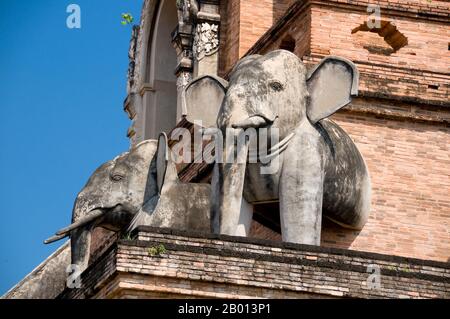 Thailandia: Elefanti adornano il chedi principale, Wat Chedi Luang, Chiang mai. Wat Chedi Luang traduce letteralmente dai thailandesi come ‘Msupremazia della Grande Stupa’. La costruzione del tempio iniziò alla fine del XIV secolo, quando il regno di LAN Na era in primo piano. Re Saen Muang ma (1385-1401) lo intendeva come il luogo di un grande reliquiario per santuare le ceneri del padre, Re Ku Na (1355-85). Oggi è il luogo del Muang di Lak o pilastro della città. La cerimonia annuale di Intakin si svolge all'interno dei confini del tempio. Foto Stock