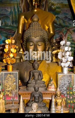 Thailandia: Buddha all'interno del viharn a Wat Phrathat Doi Kham, Chiang mai. Wat Phrathat Doi Kham o ‘Tempio del Monte d'Oro’, si trova a Tambon Mae HIA, a circa 10 km a sud della Città Vecchia di Chiang mai, nei rifugi di Doi Suthep. Il tempio registra che il tempio risale a oltre 1,300 anni ‘al 687 d.C.’, durante il periodo pre-LAN Na, quando la regione era abitata dall'animista indigeno Lawa. Chiang mai (che significa "nuova città"), talvolta scritta come "Chiengmai" o "Chiangmai", è la città più grande e culturalmente significativa della Thailandia settentrionale. Re Mengrai fondò la città nel 1296. Foto Stock