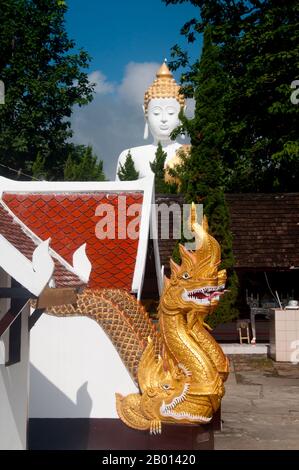 Thailandia: Balaustre Naga e Buddha gigante, Wat Phrathat Doi Kham, Chiang mai. Wat Phrathat Doi Kham o ‘Tempio del Monte d'Oro’, si trova a Tambon Mae HIA, a circa 10 km a sud della Città Vecchia di Chiang mai, nei rifugi di Doi Suthep. Il tempio registra che il tempio risale a oltre 1,300 anni ‘al 687 d.C.’, durante il periodo pre-LAN Na, quando la regione era abitata dall'animista indigeno Lawa. Chiang mai (che significa "nuova città"), talvolta scritta come "Chiengmai" o "Chiangmai", è la città più grande e culturalmente significativa della Thailandia settentrionale. Re Mengrai fondò la città nel 1296. Foto Stock
